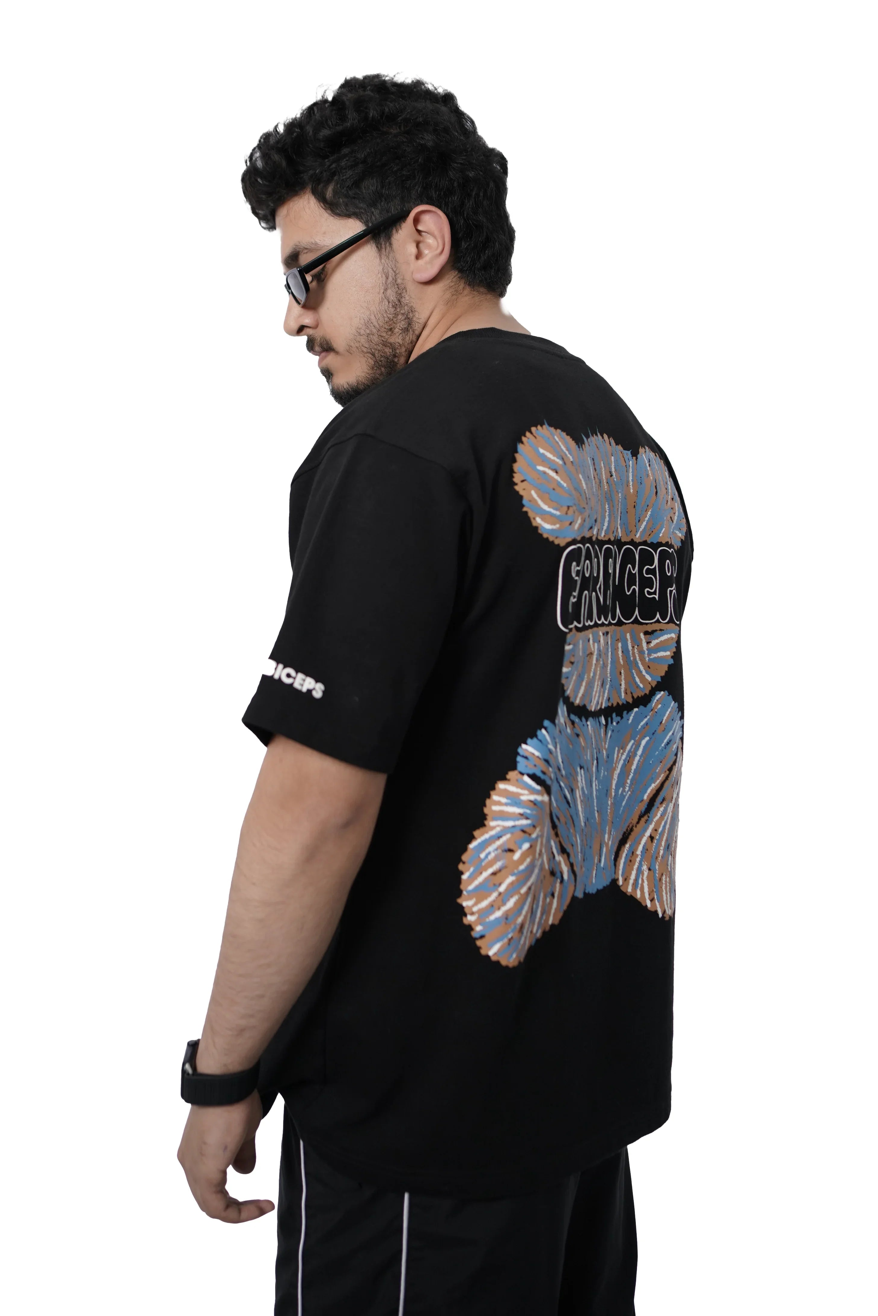 Person wearing Bearbiceps black t-shirt with colorful bear designs on the back, standing against a white background